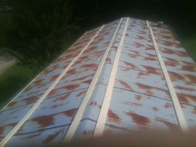 Rusted metal roof panels with new wood purlins before replacement — Storm Damage Roof Repair in East Otis by Roofing Brothers
